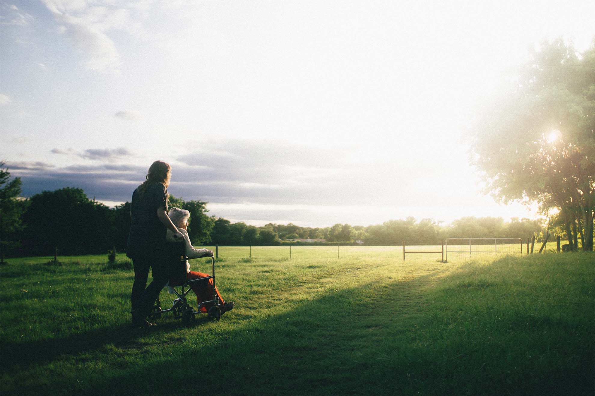 resident and carer on a walk in a field