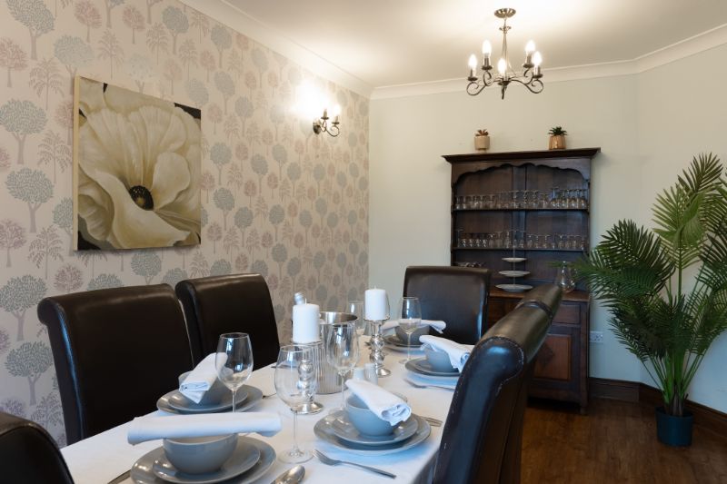 one of our dining tables setup with candles, cutlery and plates