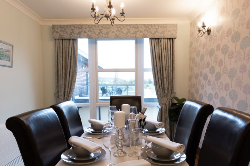 one of our dining tables setup with cutlery and plates