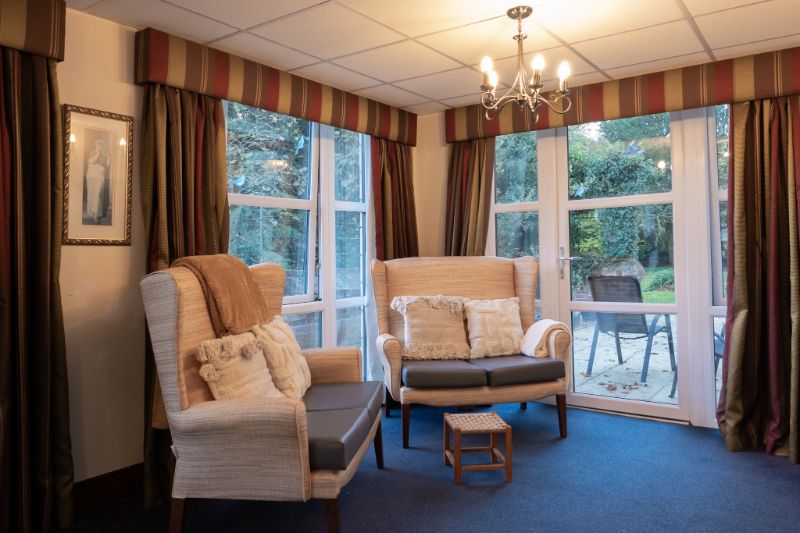 view of two sofas with a small footrest with a garden view