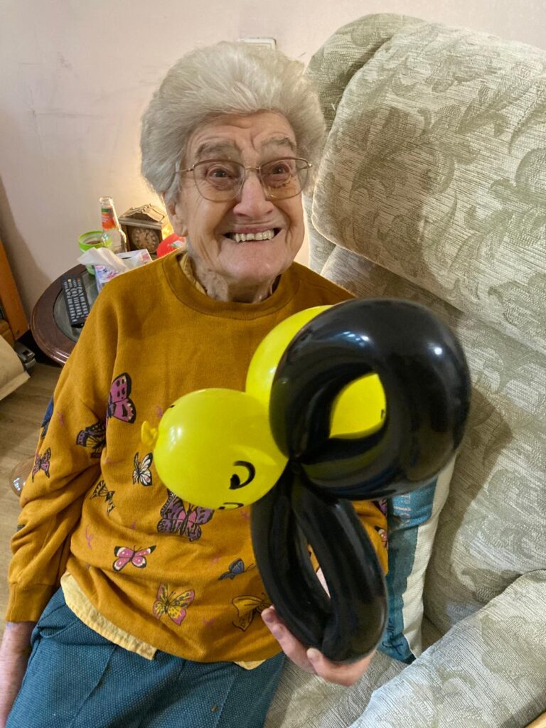 resident smiling with her balloon model