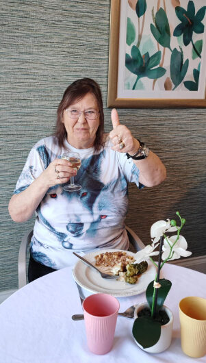 resident enjoying their meal with their thumb up