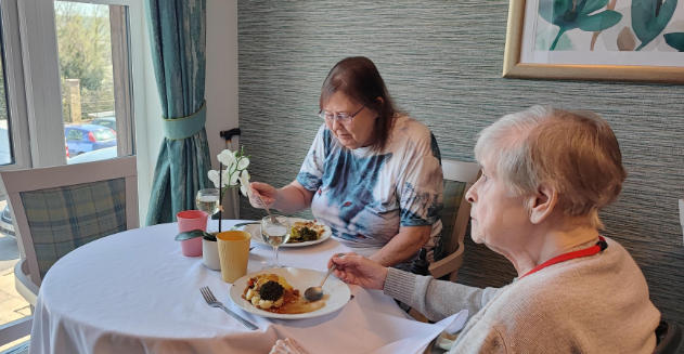 two of our residents sat at the table enjoying their meal