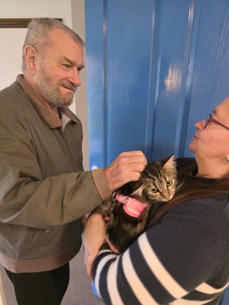 man petting cat