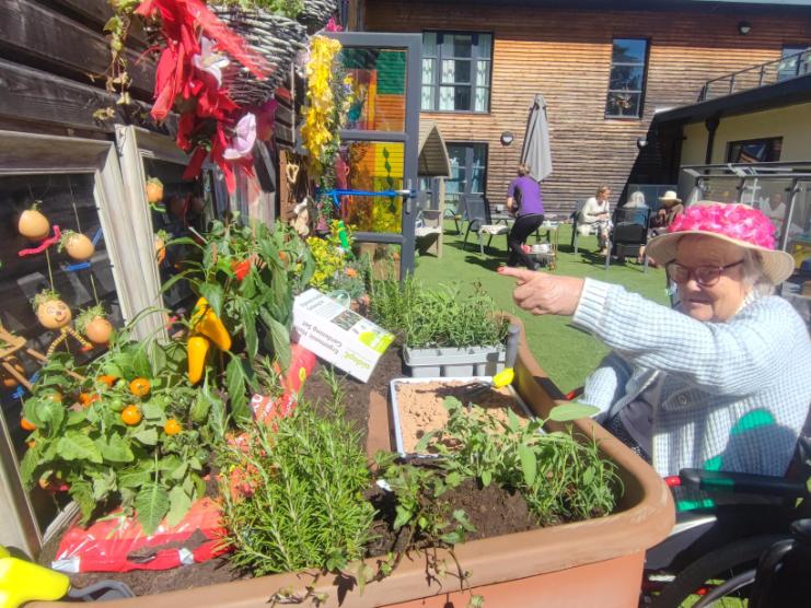 a resident in the garden pointing at plants