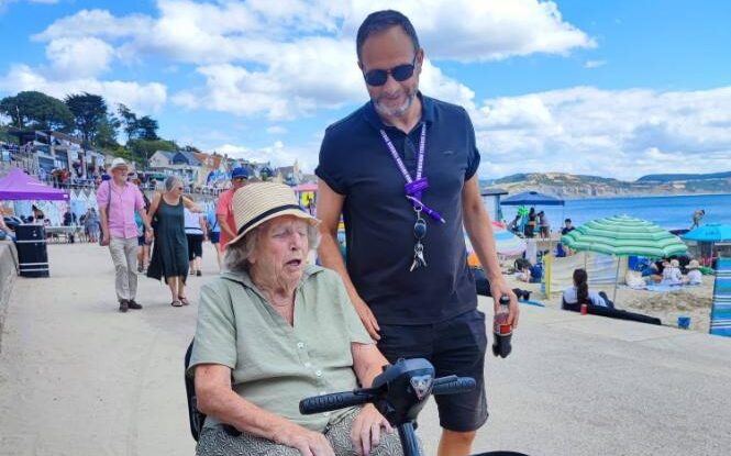 older lady on a mobility scooter by the beach
