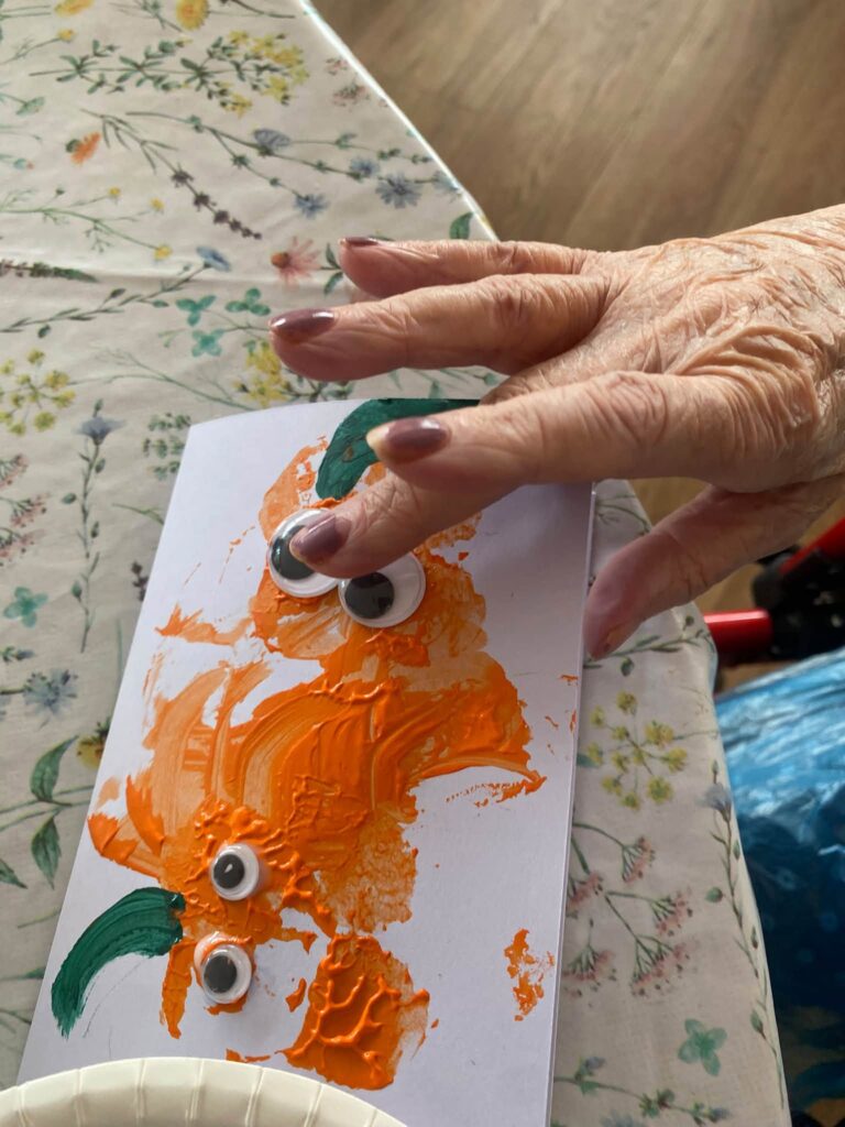a close up of a residents hand on a halloween painting