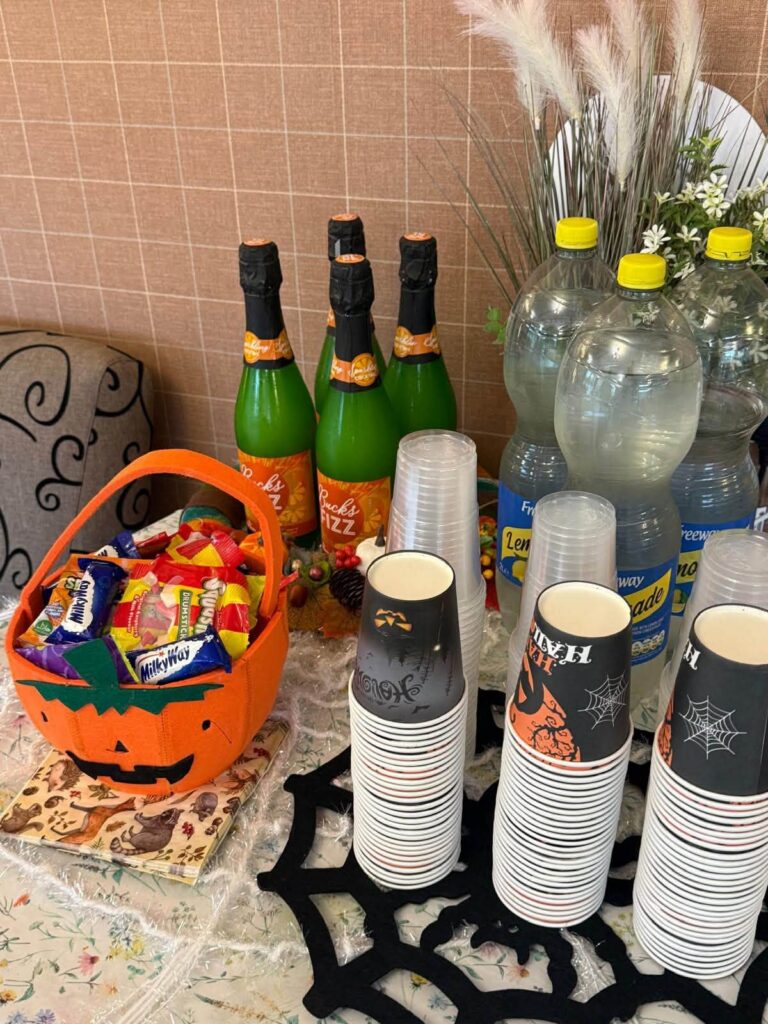 halloween bucket filled with sweets next to cups and drinks